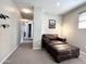 Relaxing sitting area with leather chair, ottoman, and neutral carpeted floors at 1042 S Cheshire Ln, Gilbert, AZ 85296