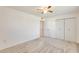 Well-lit bedroom includes neutral carpeting, a ceiling fan, and a closet with double doors at 10891 W Clair Dr, Sun City, AZ 85351