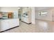 Bright kitchen with tile floors, white cabinets, and view into the adjacent living room at 10891 W Clair Dr, Sun City, AZ 85351