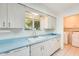 Bright kitchen with white cabinets, blue countertops and white appliances at 10891 W Clair Dr, Sun City, AZ 85351