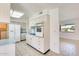 Bright kitchen with tile floors, and white appliances, with view into the adjacent living room at 10891 W Clair Dr, Sun City, AZ 85351