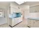 Bright kitchen featuring white cabinets with matching appliances and blue countertops at 10891 W Clair Dr, Sun City, AZ 85351