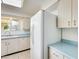 Bright kitchen featuring white cabinets and appliances with light blue countertops at 10891 W Clair Dr, Sun City, AZ 85351