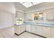 Bright kitchen with tile floors, white cabinets, and view into the adjacent living room at 10891 W Clair Dr, Sun City, AZ 85351