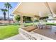 Charming covered patio featuring a tiled floor, decorative border, and views of the landscaped backyard at 10891 W Clair Dr, Sun City, AZ 85351