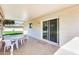 Inviting covered patio with sliding glass door, tiled flooring, and view of the expansive backyard at 10891 W Clair Dr, Sun City, AZ 85351