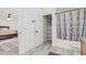 Bathroom view showing tiled floors, tub/shower combo with patterned curtain and a storage closet with shelving at 1114 S Grenoble --, Mesa, AZ 85208