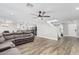 Open-concept living room with hardwood floors, a ceiling fan, and a view into the kitchen and dining room at 1114 S Grenoble --, Mesa, AZ 85208