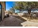 View of the backyard with block wall, large trees and patio at 11354 W Carousel Dr, Arizona City, AZ 85123