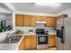 Well-lit kitchen featuring stainless steel appliances, light countertops, and plentiful wood cabinetry at 11354 W Carousel Dr, Arizona City, AZ 85123