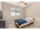 Neutral bedroom with a ceiling fan and a large window showing backyard landscape and lots of natural light at 11457 W Madisen Ellise Dr, Surprise, AZ 85378