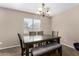 Cozy dining room featuring a wooden table, bench seating, and a chandelier for a warm ambiance at 11457 W Madisen Ellise Dr, Surprise, AZ 85378