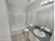 Well-lit bathroom featuring a shower-tub combo, vanity with sink, and a large mirror at 11595 W Holly St, Avondale, AZ 85392