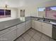 Bright and functional kitchen with stainless steel sink, white cabinets, and backyard views at 11595 W Holly St, Avondale, AZ 85392