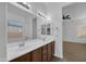 Bright bathroom with a dual sink vanity, white countertops and wood cabinets at 11910 W Daley Ct, Sun City, AZ 85373