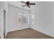 Bedroom with neutral carpet, ceiling fan, and large window offering natural light at 11910 W Daley Ct, Sun City, AZ 85373