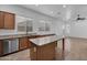 Open kitchen featuring granite countertops, wood cabinets, an island and tile flooring at 11910 W Daley Ct, Sun City, AZ 85373