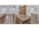 Open kitchen featuring granite countertops, wood cabinets, an island and tile flooring at 11910 W Daley Ct, Sun City, AZ 85373