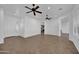 Bright, open-concept living room with tile floors, ceiling fans, and white walls at 11910 W Daley Ct, Sun City, AZ 85373