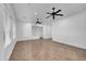 Bright, open-concept living room with tile floors, ceiling fans, and white walls at 11910 W Daley Ct, Sun City, AZ 85373