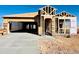 New construction home featuring an unfinished front yard with a two-car garage and a covered front entry at 11928 E Aster Ln, Florence, AZ 85132