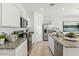 Modern kitchen featuring white cabinets, granite countertops, stainless steel appliances, and an island sink at 11980 E Aster Ln, Florence, AZ 85132