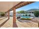 Covered patio view of a backyard pool with desert landscaping, brick pillars, and mountain views at 1201 W Dahlia Dr, Phoenix, AZ 85029