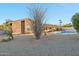 Exterior shot of a desert home with a private pool, desert landscaping, and brick exterior at 1201 W Dahlia Dr, Phoenix, AZ 85029