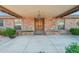 Inviting covered front porch with brick columns and a beautiful wooden front door at 1201 W Dahlia Dr, Phoenix, AZ 85029