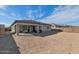 Spacious backyard, featuring a covered patio with seating area, ready for landscaping at 12716 W Mclellan Rd, Glendale, AZ 85307