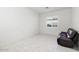 Bedroom featuring a window, tile flooring, and a comfortable recliner, great for relaxation at 12716 W Mclellan Rd, Glendale, AZ 85307