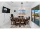 Bright dining room with a modern chandelier, seating for six, and access to the backyard through sliding glass doors at 12716 W Mclellan Rd, Glendale, AZ 85307