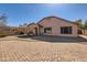 Large backyard featuring extensive brick pavers, low-maintenance landscaping, and a covered patio area at 13594 W Port Royale Ln, Surprise, AZ 85379