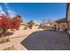 Expansive backyard with a paver patio, trees, and an outdoor kitchen area at 13594 W Port Royale Ln, Surprise, AZ 85379