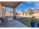 Inviting covered patio overlooking a spacious backyard with desert landscaping and a seating area at 13594 W Port Royale Ln, Surprise, AZ 85379