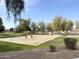 Outdoor basketball court with players on a sunny day in a well-maintained park at 13594 W Port Royale Ln, Surprise, AZ 85379