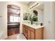 Bathroom with a double sink vanity, decorative mirror and lighting, with a view into the bedroom at 13594 W Port Royale Ln, Surprise, AZ 85379