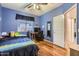 Bedroom with blue walls, a ceiling fan, and wood-look flooring at 13594 W Port Royale Ln, Surprise, AZ 85379