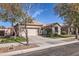 Well-kept home with mature trees, green lawn, a driveway and a two-car garage in a quiet neighborhood at 13594 W Port Royale Ln, Surprise, AZ 85379