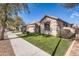 Charming single-story home featuring a well-manicured lawn and desert landscaping at 13594 W Port Royale Ln, Surprise, AZ 85379