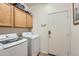 Bright laundry room with modern side-by-side washer and dryer at 13594 W Port Royale Ln, Surprise, AZ 85379