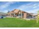 Green backyard with a covered patio, pool, and barbecue area perfect for entertaining at 1363 N Mckenna Ln, Gilbert, AZ 85233