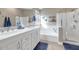 Bright bathroom with double sinks, white cabinetry, a soaking tub, a separate glass-enclosed shower, and modern fixtures at 1363 N Mckenna Ln, Gilbert, AZ 85233