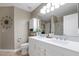 Bathroom featuring double sinks with white countertops, a large mirror, and a shower with a decorative curtain at 1363 N Mckenna Ln, Gilbert, AZ 85233