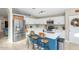 Modern kitchen with white cabinetry, stainless steel appliances, a blue island with barstool seating, and ample counter space at 1363 N Mckenna Ln, Gilbert, AZ 85233