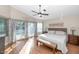 Sunlit main bedroom featuring a ceiling fan, a sliding glass door to the backyard, and laminate wood flooring at 1363 N Mckenna Ln, Gilbert, AZ 85233