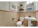 Cozy powder room with tiled walls, decorative accents, and modern fixtures at 14674 W Windsor Ave, Goodyear, AZ 85395