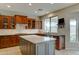 Bright kitchen featuring wood cabinets, tile backsplash, stainless appliances, and a gray center island at 14674 W Windsor Ave, Goodyear, AZ 85395