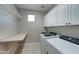 Functional laundry room with cabinets, sink, and modern washer/dryer at 14674 W Windsor Ave, Goodyear, AZ 85395