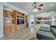 Living room with a hardwood floor, built in shelves, and a partial view of the kitchen and dining area at 14674 W Windsor Ave, Goodyear, AZ 85395